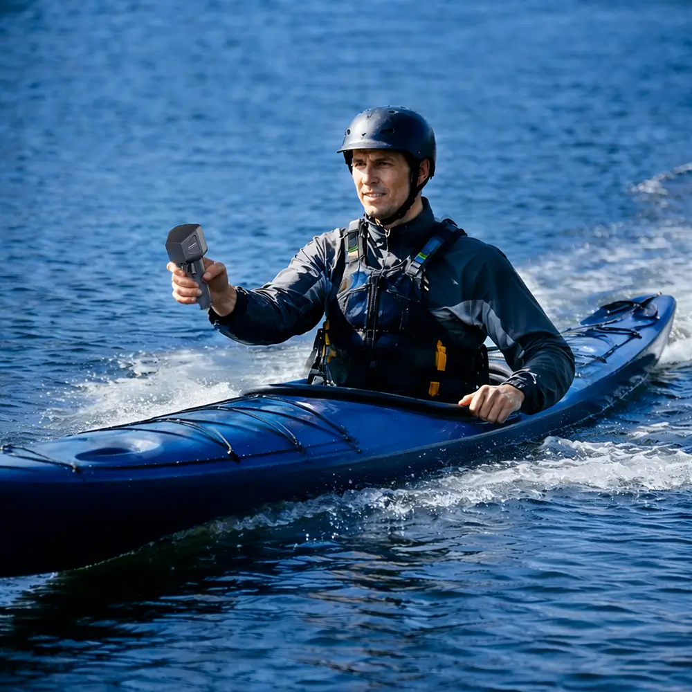 A paddler in a blue inflatable kayak exploring a scenic waterway. The EDGE K4 motor provides silent, effortless propulsion for extended kayaking trips.