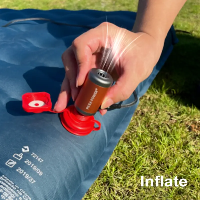 Close-up of TEDGIX TurboBean air pump using the bottom port to inflate a camping sleeping pad.