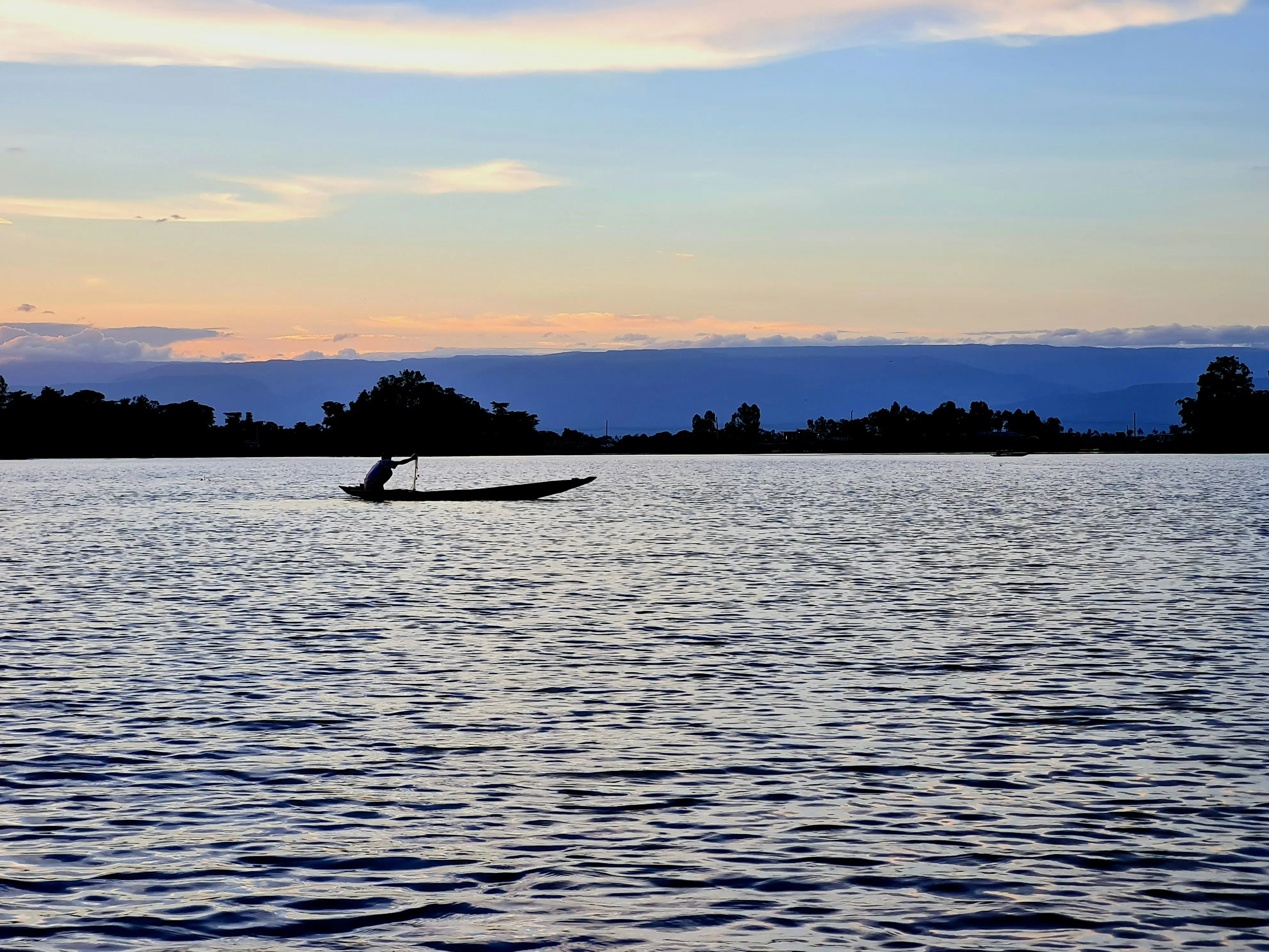 Angler paddling a kayak across open water, emphasizing distance, endurance, and physical effort