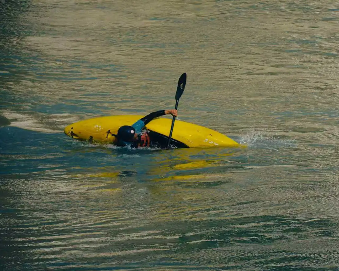 Kayak maneuvering in moving water, highlighting the importance of lightweight and balanced propulsion systems